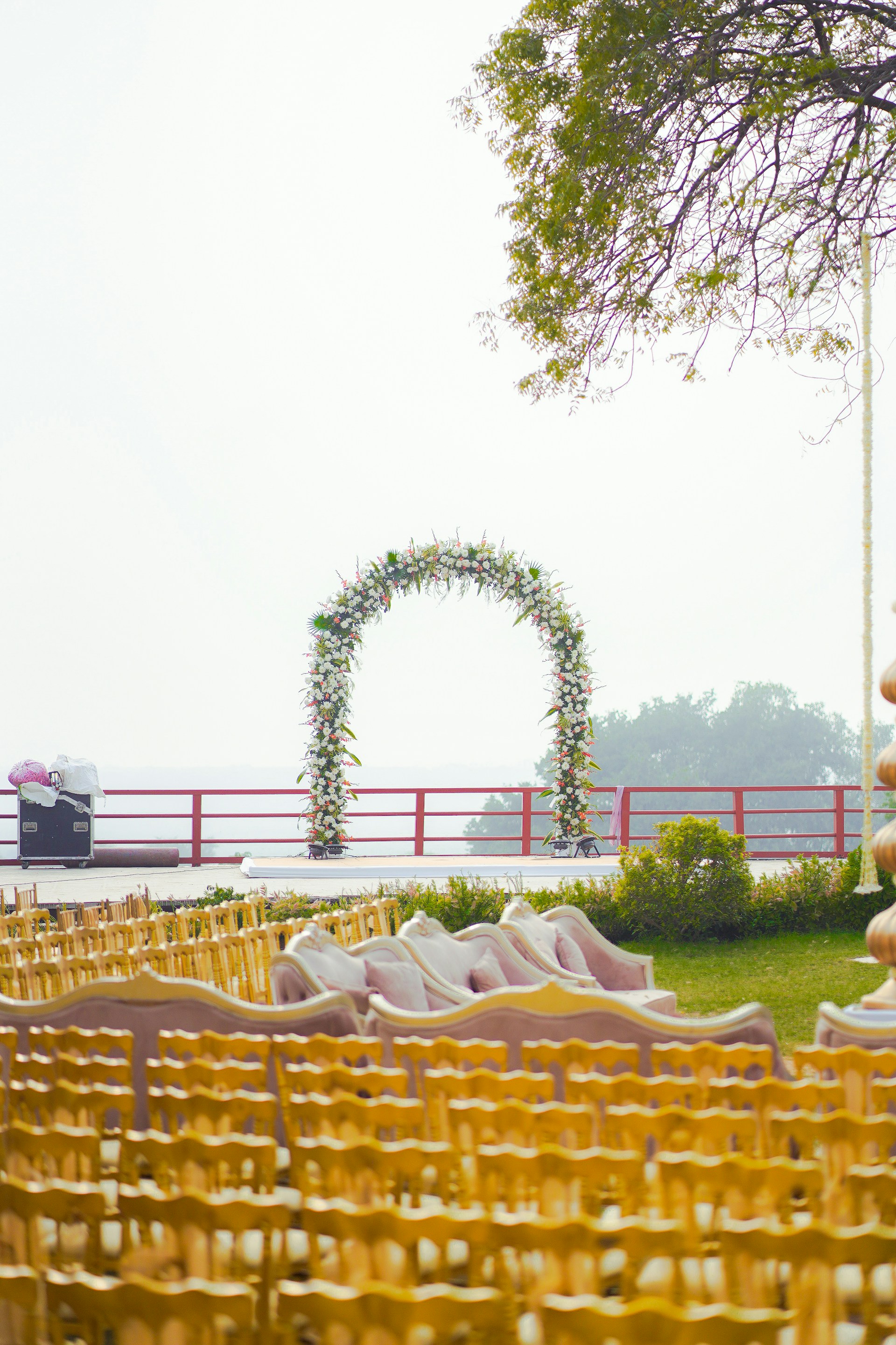 A wedding ceremony setup with floral arch and seating.