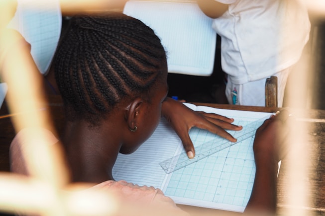 A student carefully draws lines with a ruler.