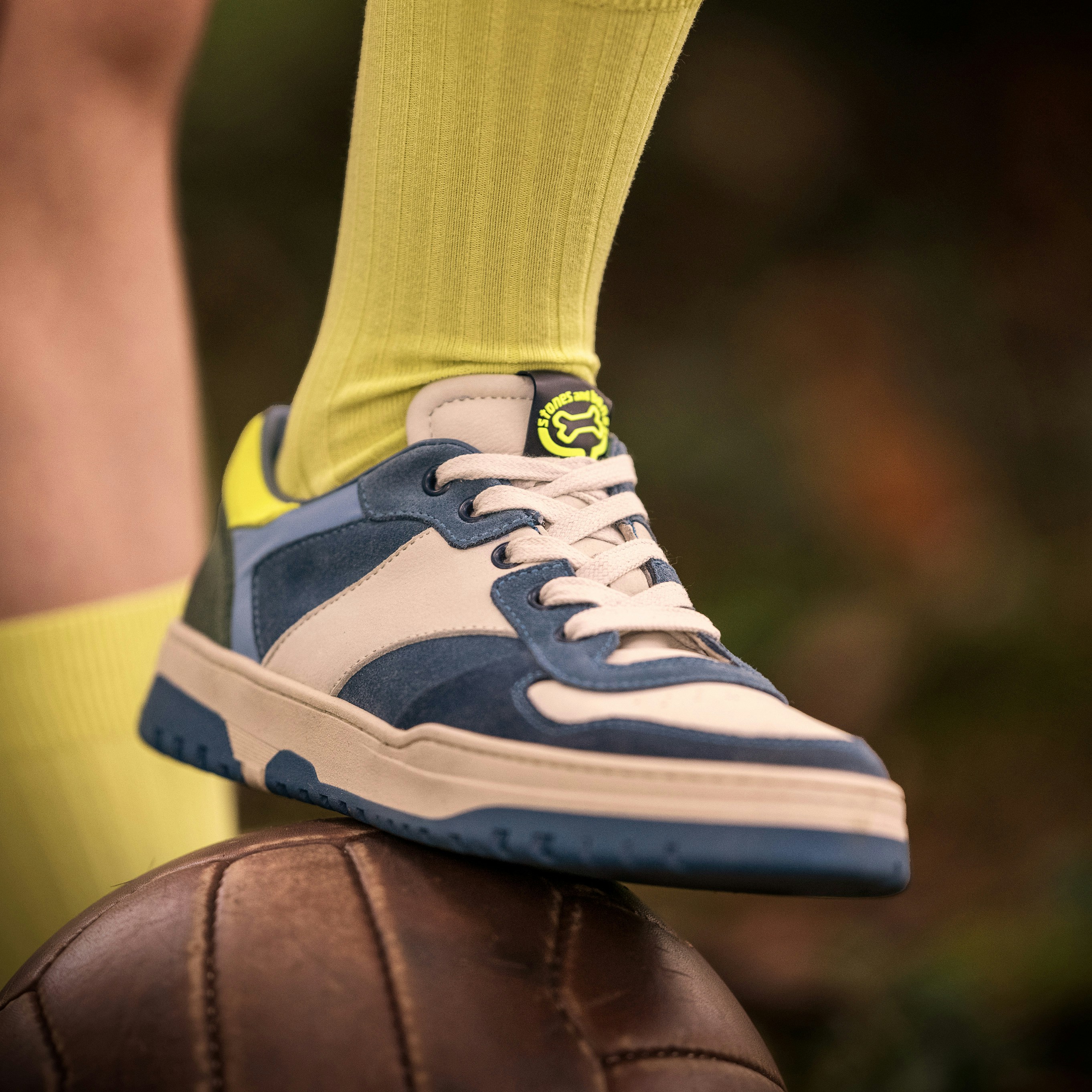 A sneaker rests on a soccer ball.