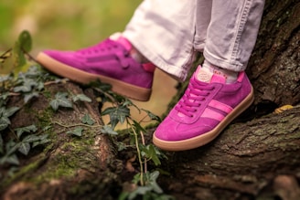 A person wears bright pink sneakers outside.