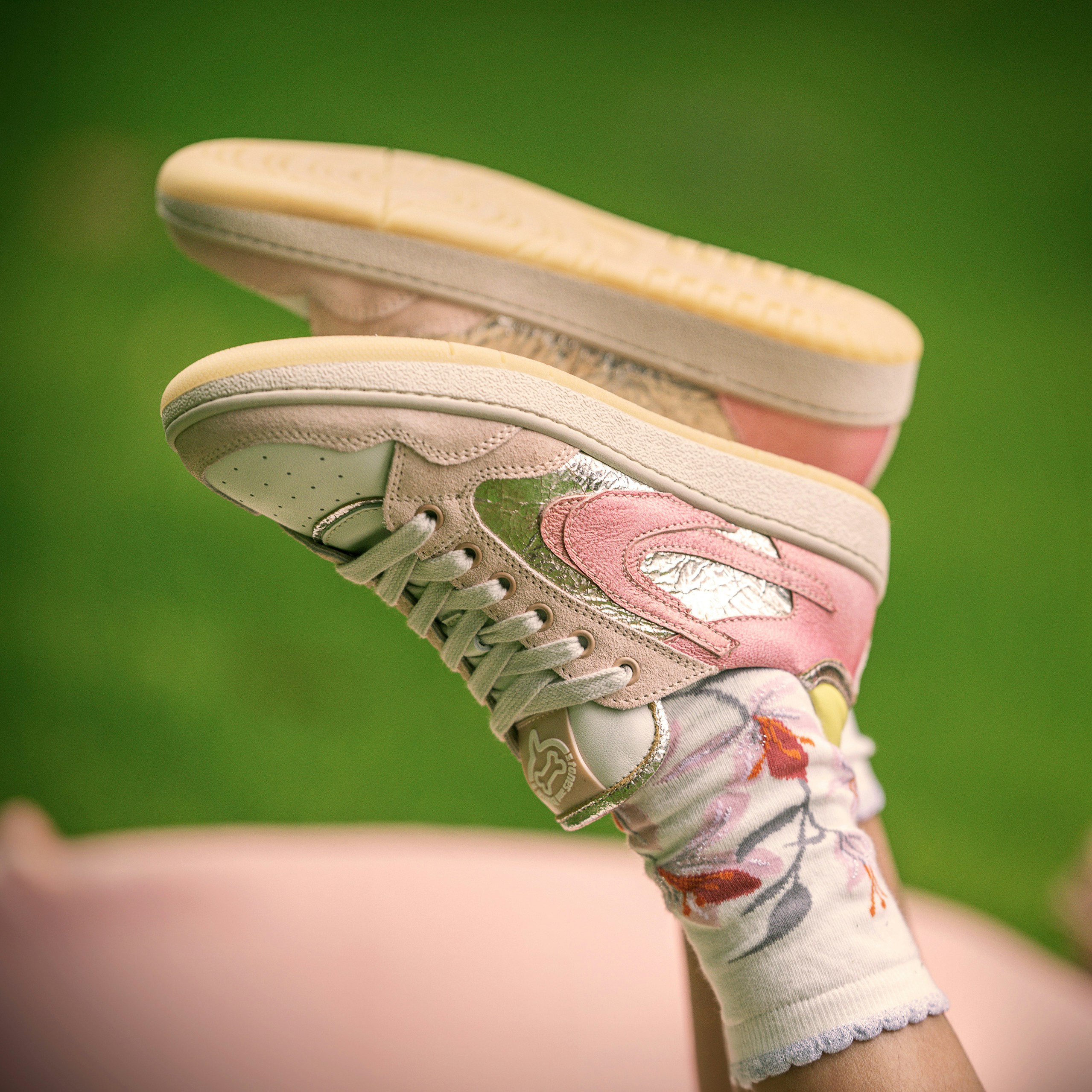 Pink sneakers and socks are shown in a shot.