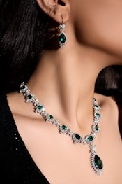 Jewelry with emeralds adorns a woman's neck.