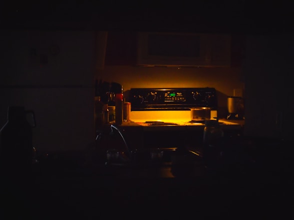 A dimly lit kitchen with oven light.