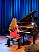 A girl plays the piano on stage.