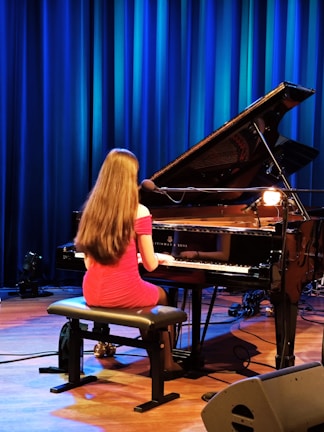 A girl plays the piano on stage.