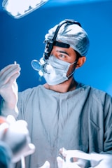 A surgeon examines a medical instrument during surgery.