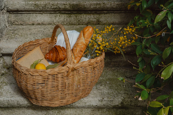 Picnic basket, bread, and pastries ready to enjoy.