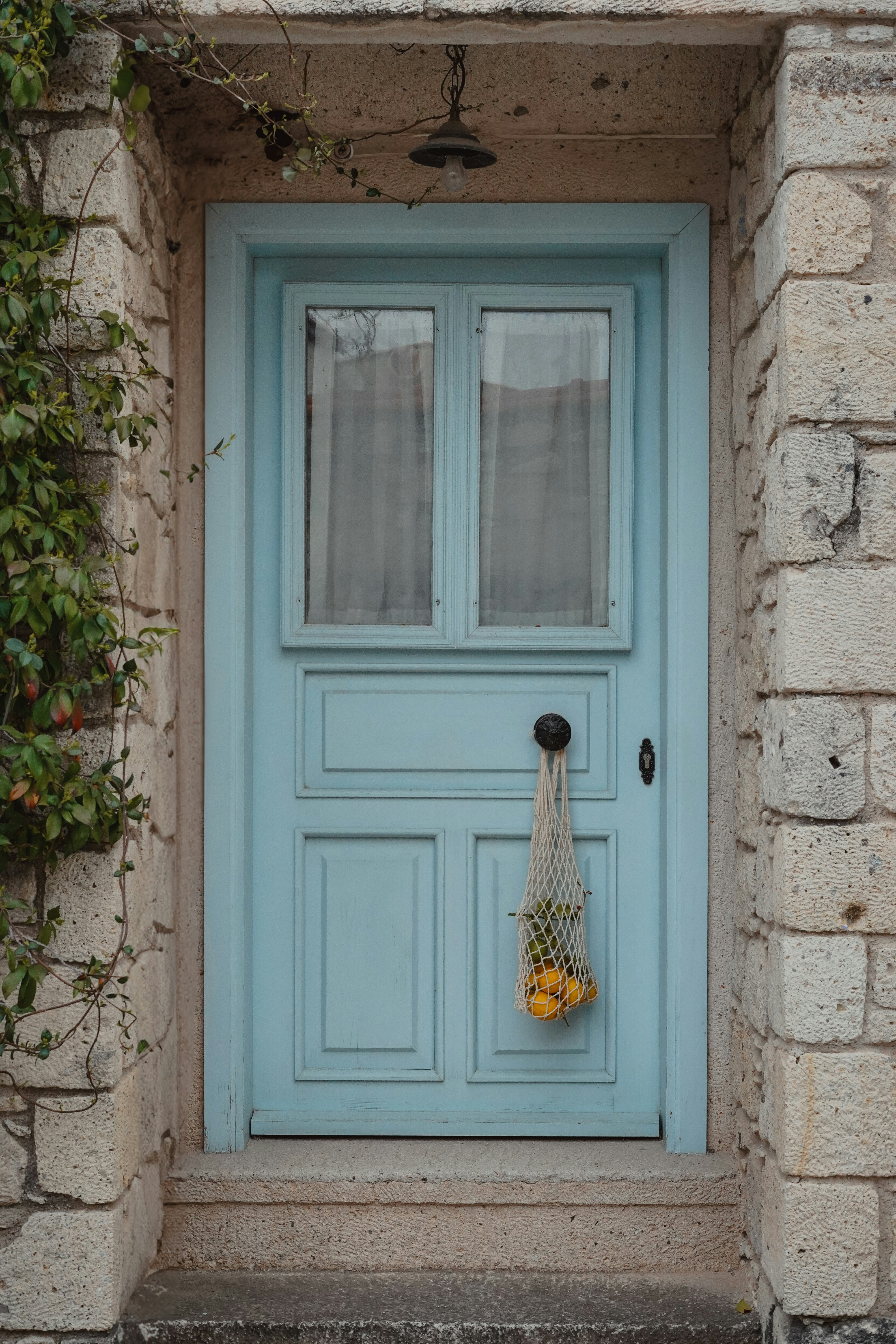 A blue door with a bag of fruit