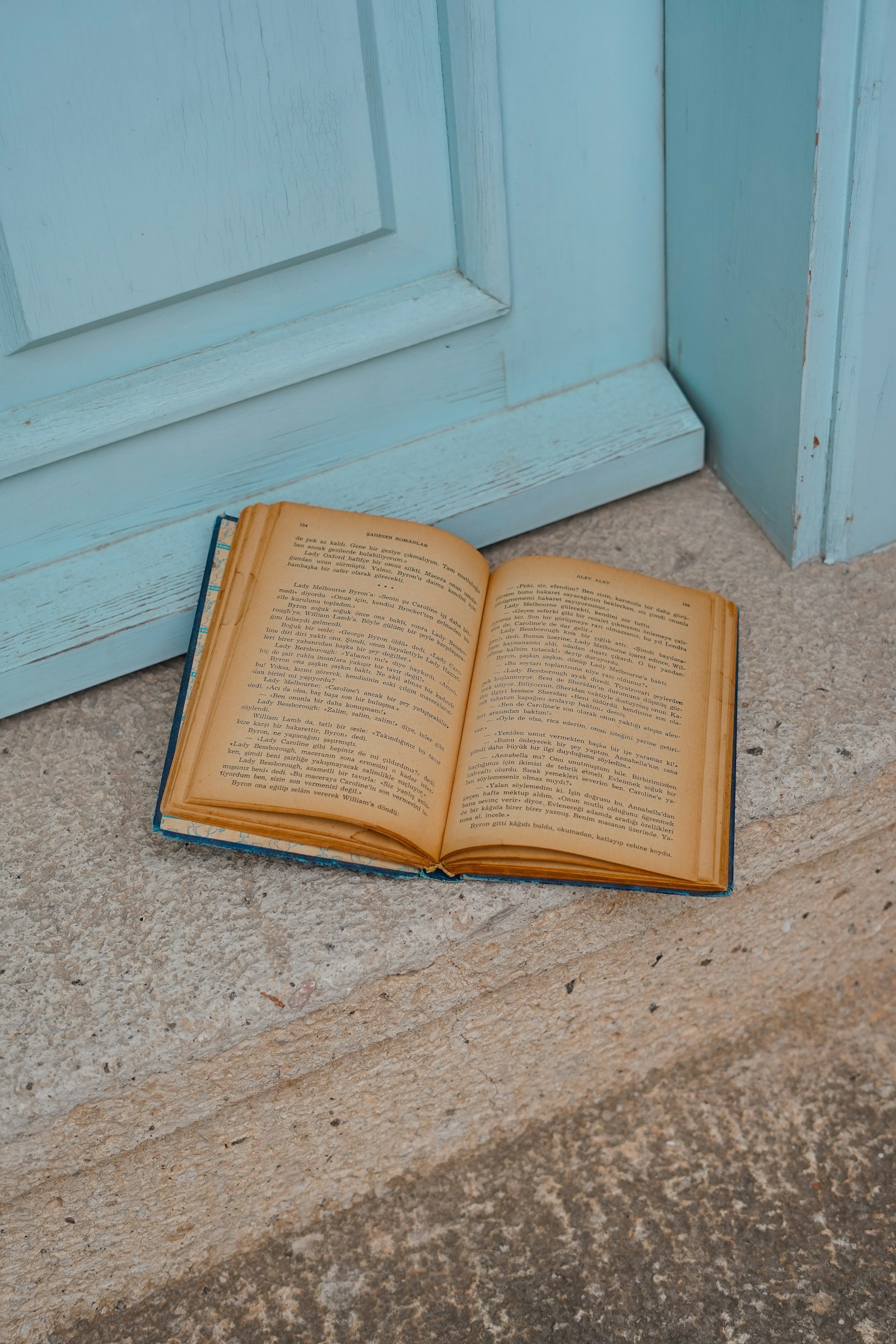Open book lies near a blue door.