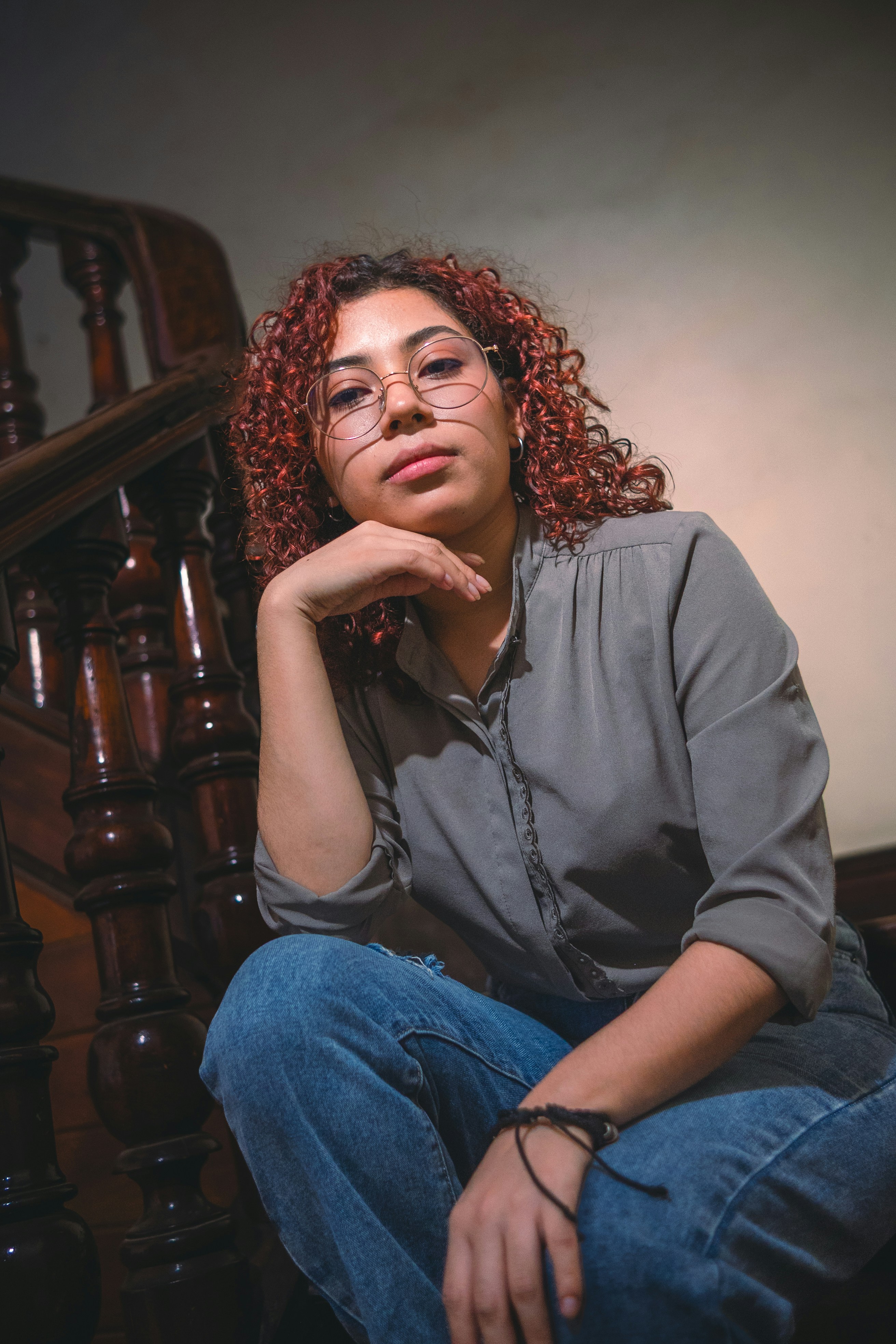 Woman with curly hair poses on the staircase.