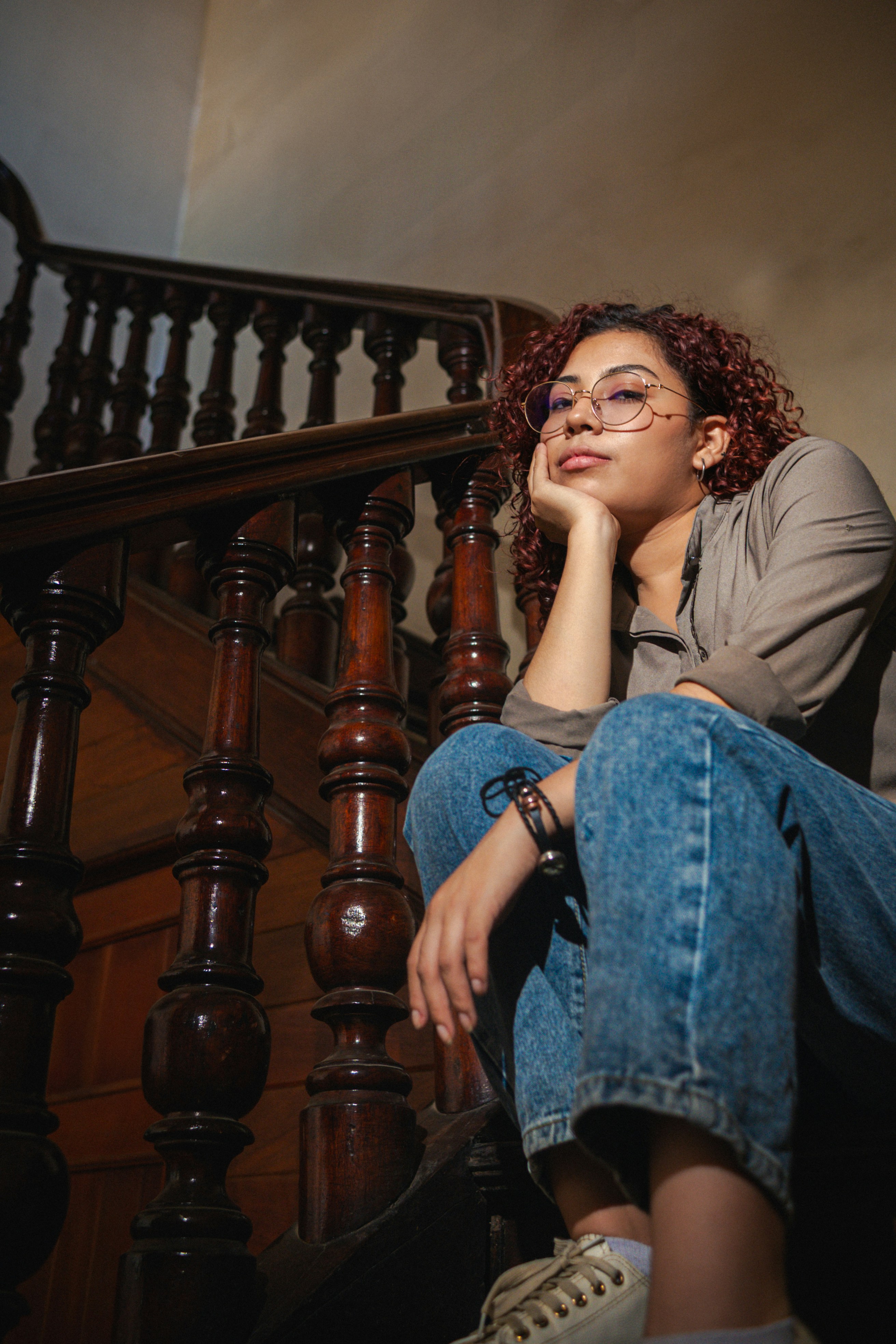A woman contemplates while sitting on the stairs.