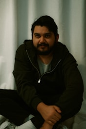 A man in a hoodie poses for a picture.