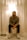 A man sits underneath a lit lamp.