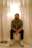 A man sits underneath a lit lamp.