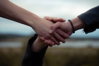 Two people shake hands, possibly a deal.