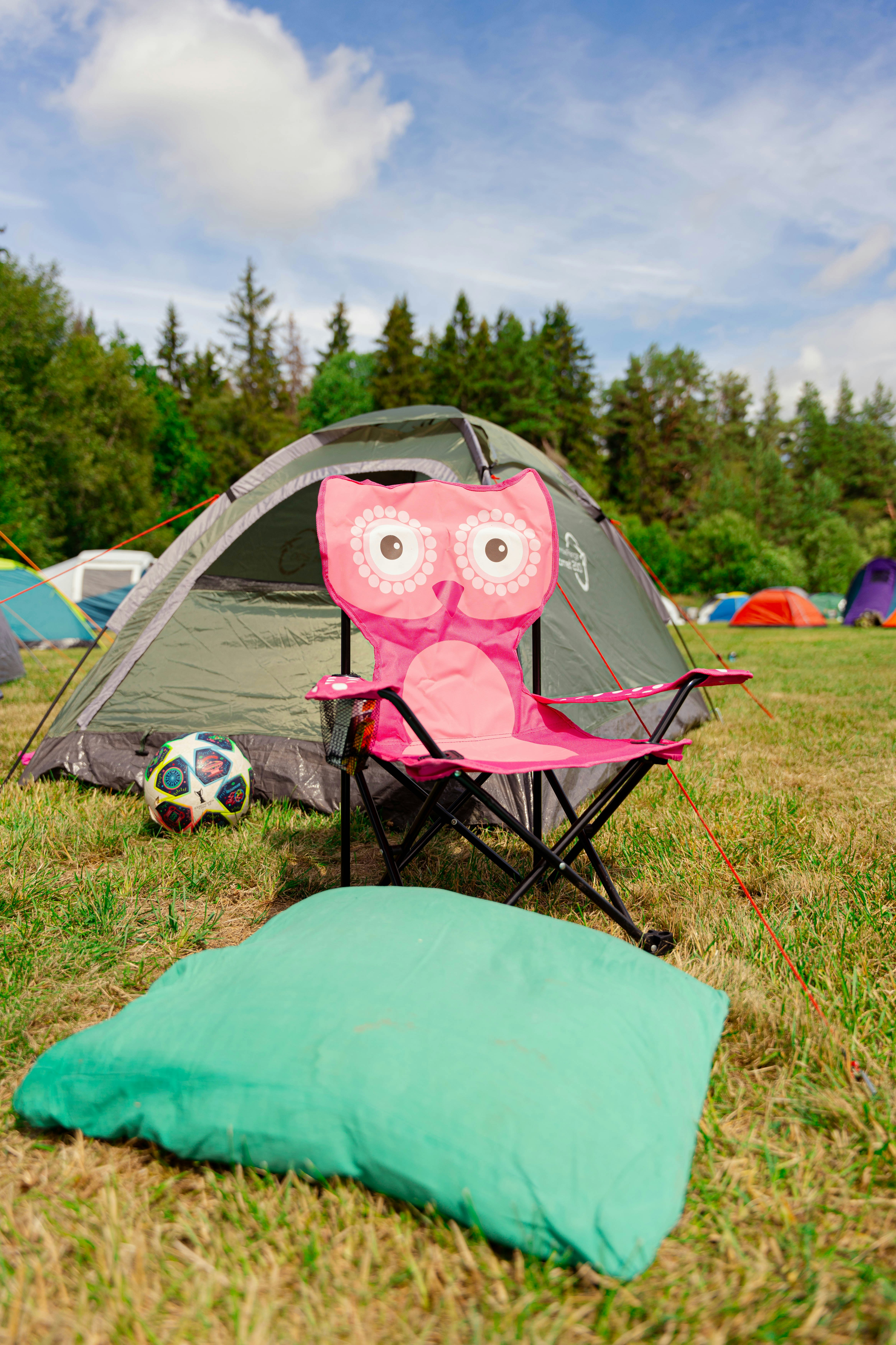 Camping gear sits out on a grassy field.