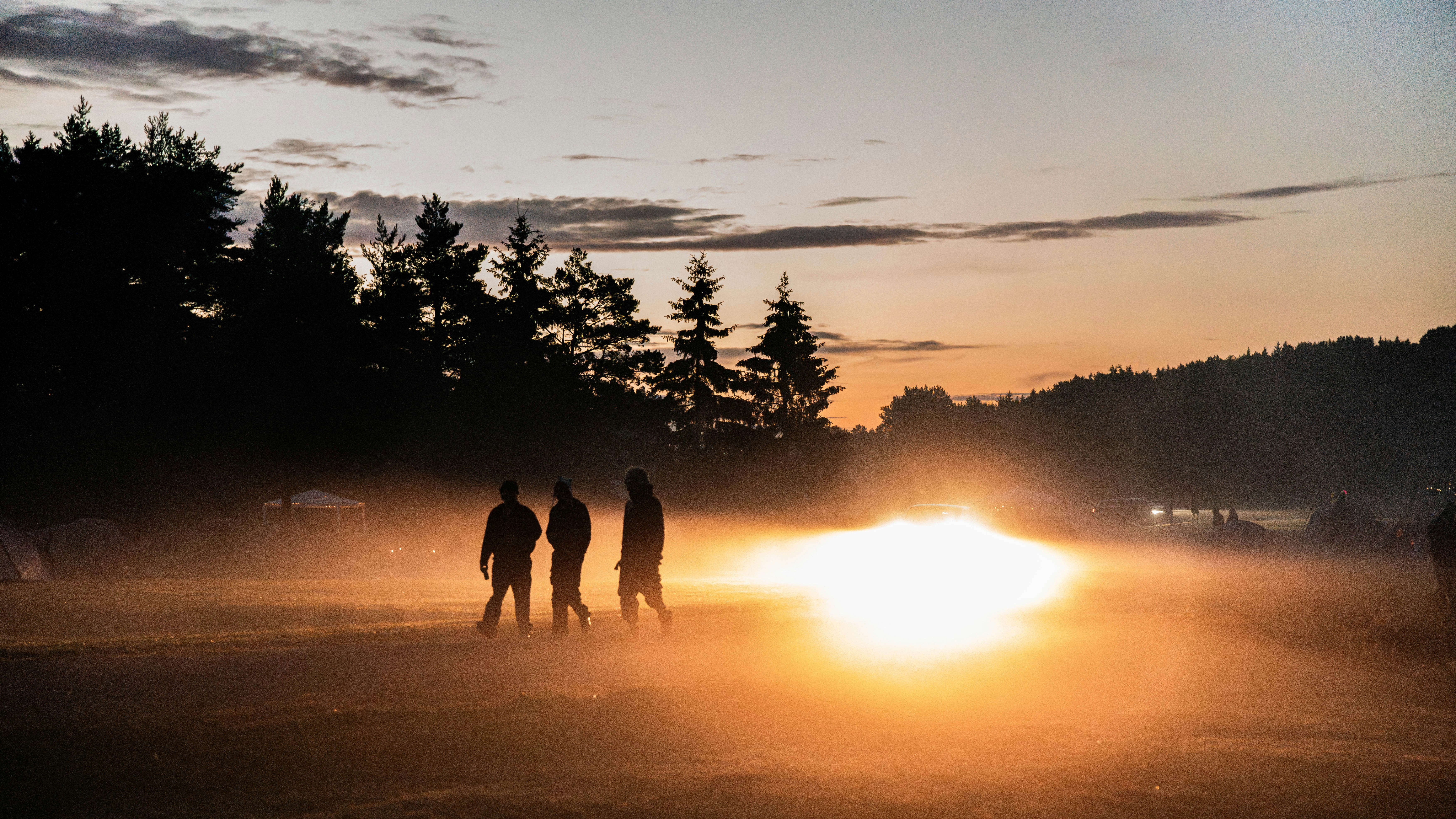 People walk through the fog at sunset