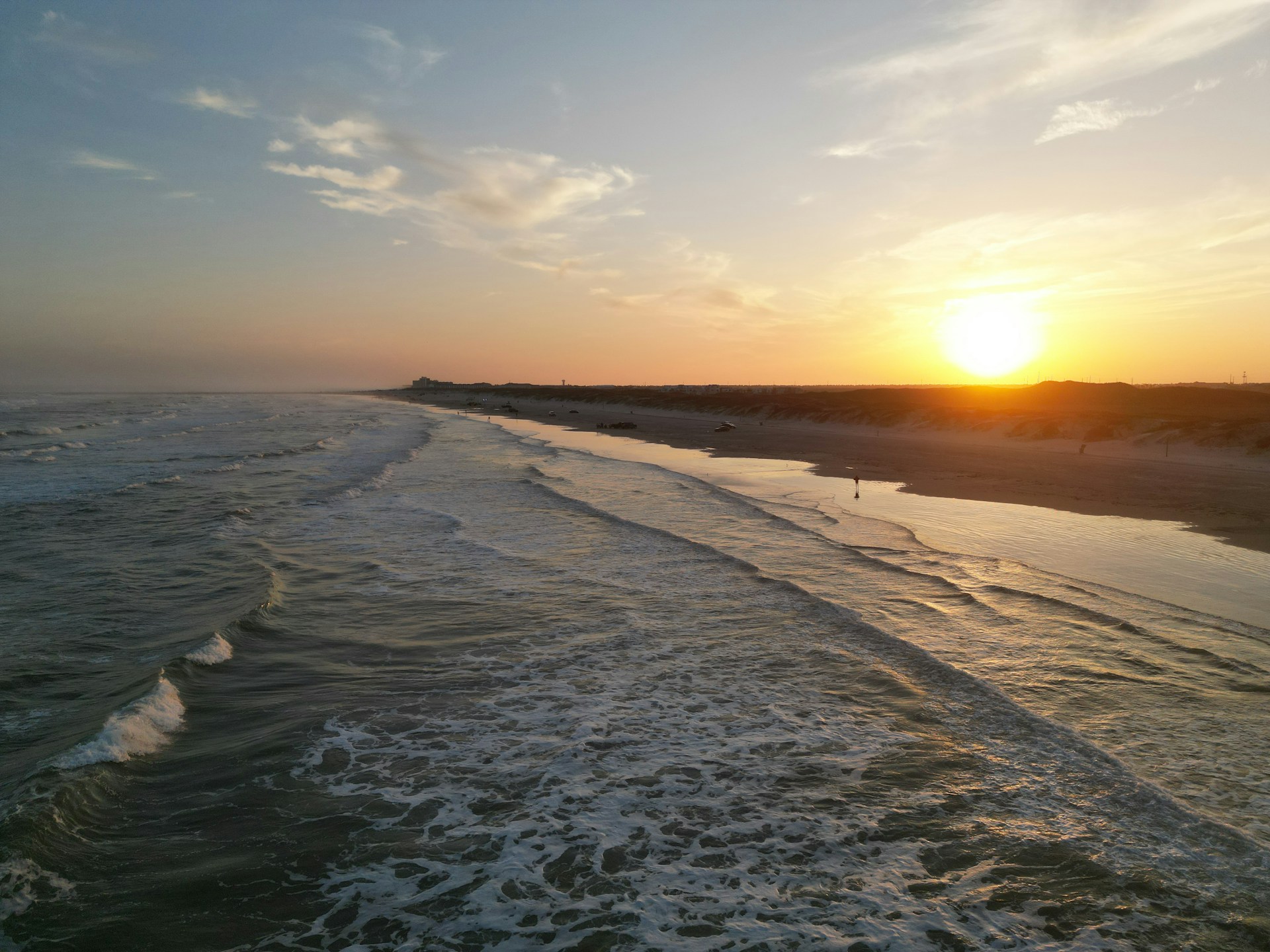 Waves roll onto the shore during a beautiful sunset.