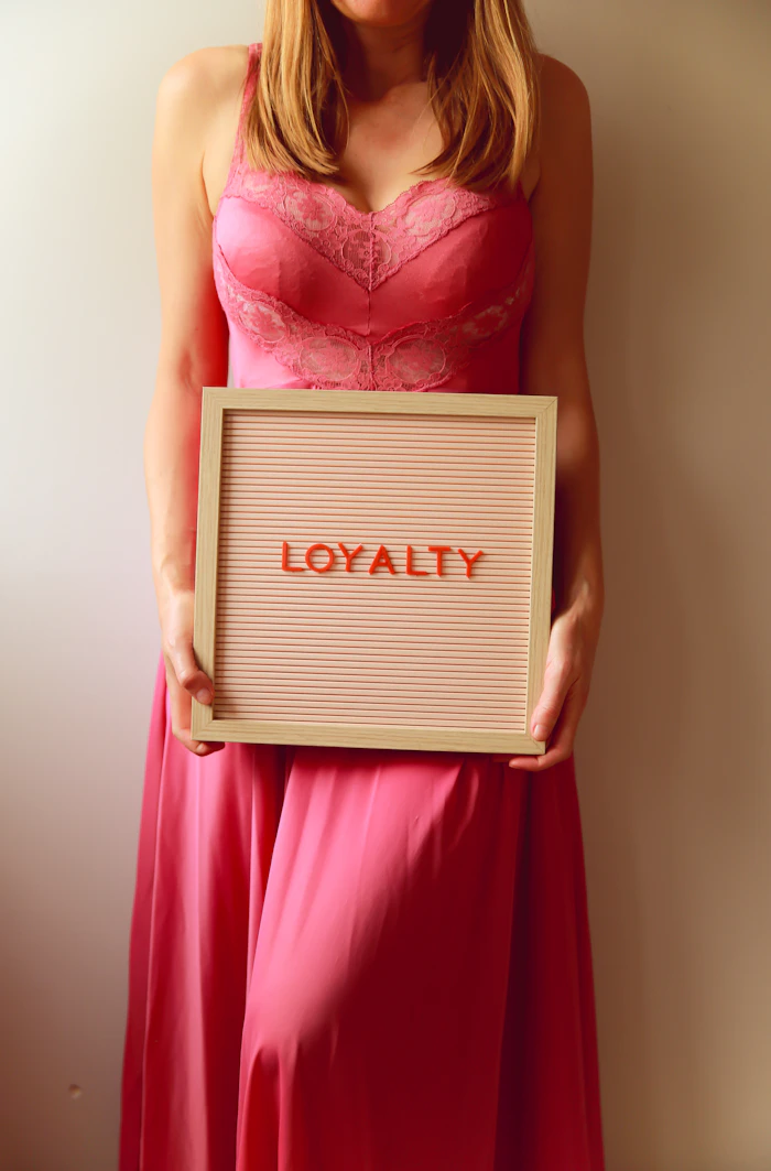 Woman holding a sign that says loyalty