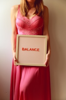 Woman holds a sign that says "balance".
