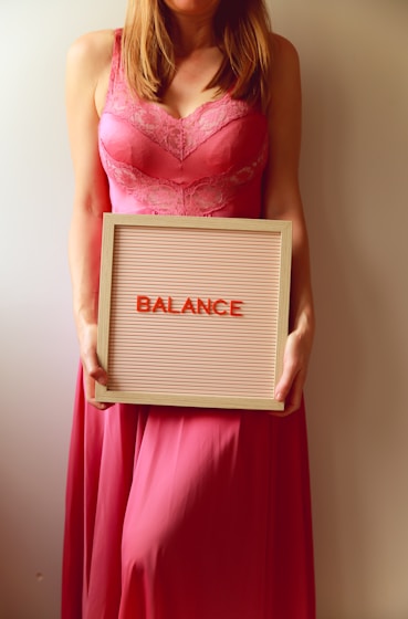 Woman holds a sign that says "balance".