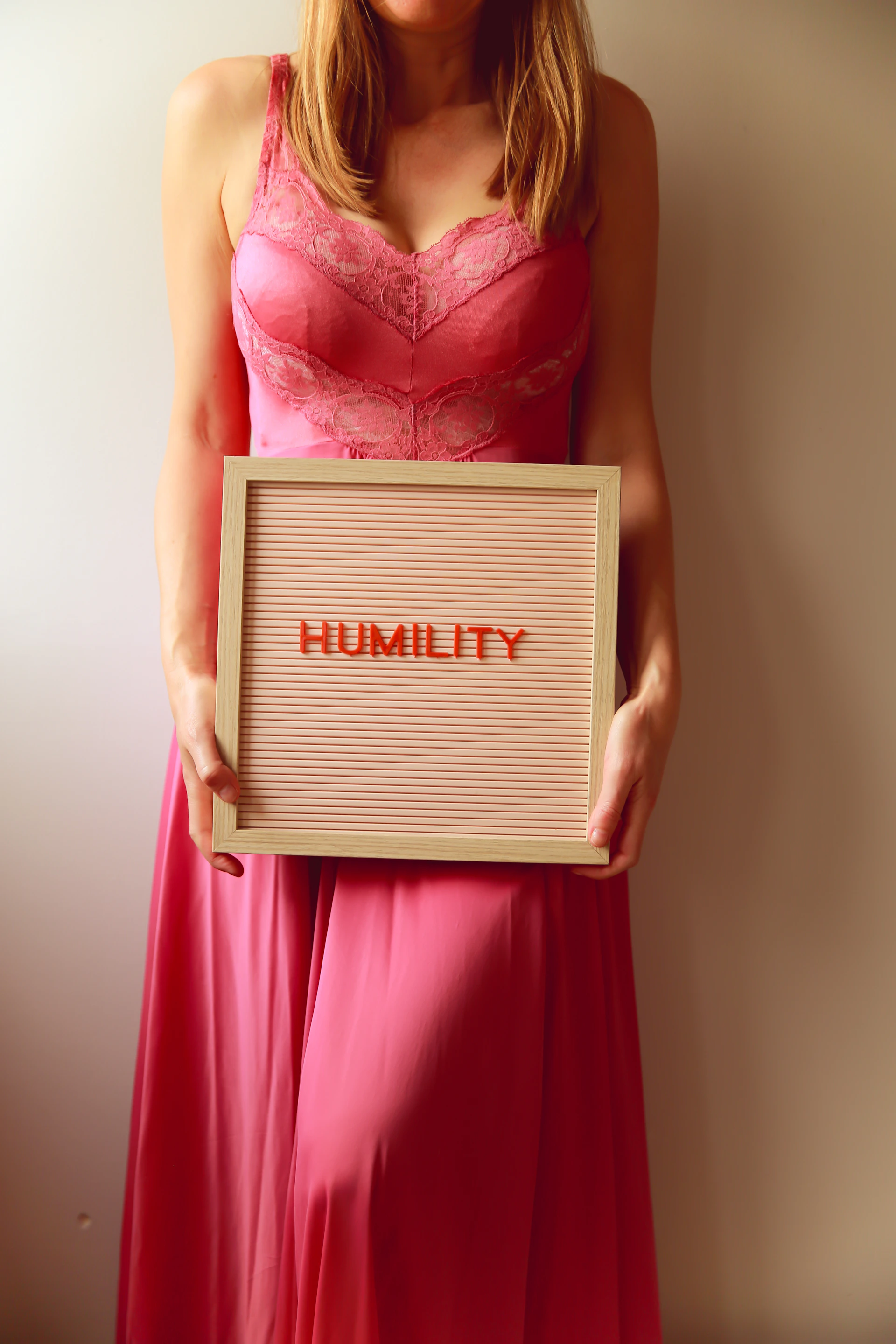 A woman holds a sign that says "humility"
