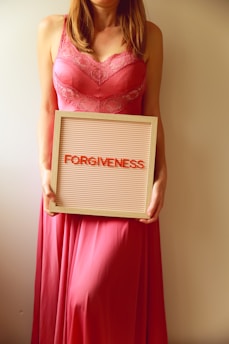 Woman holds a sign that says "forgiveness".