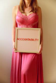 Woman holds a sign reading "accountability."