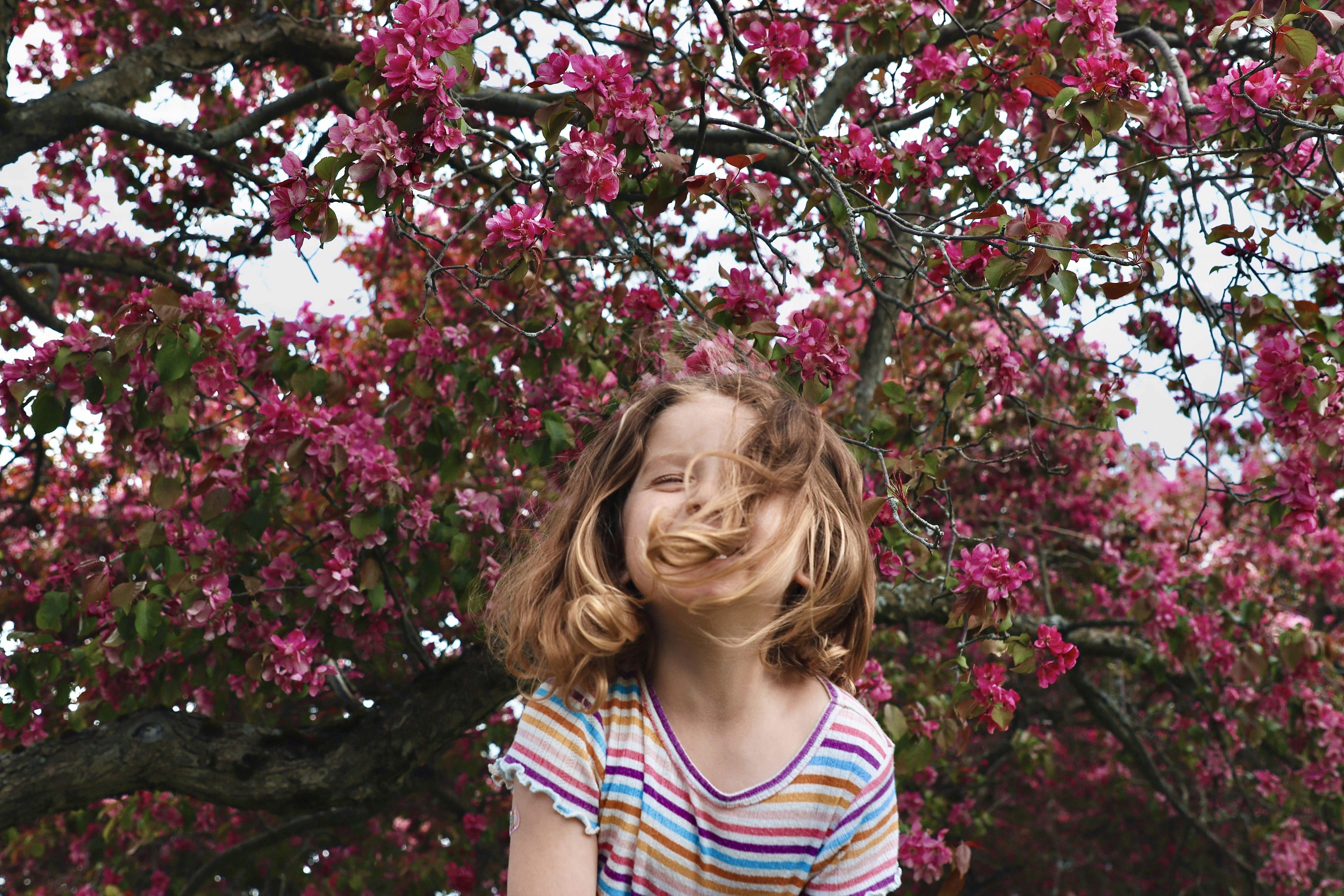 Girl smiles with blossoms in background