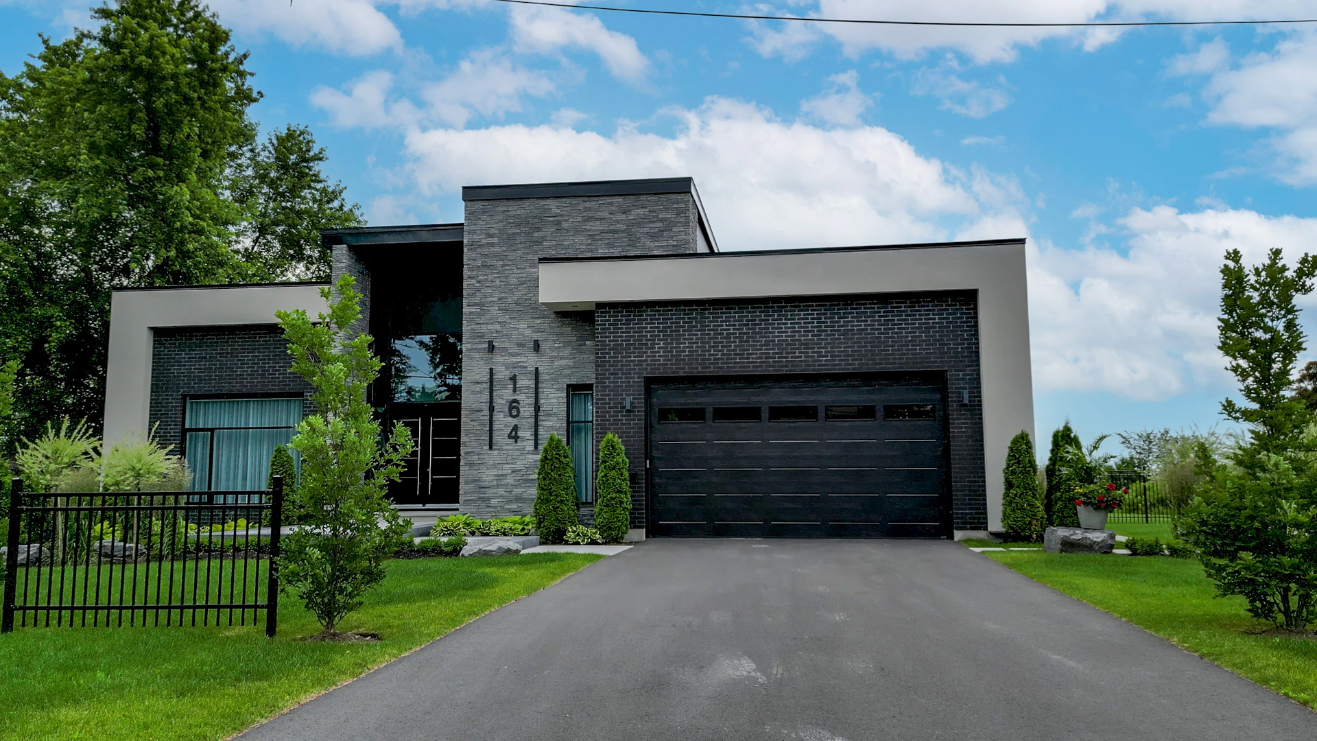 A modern house with a black garage.