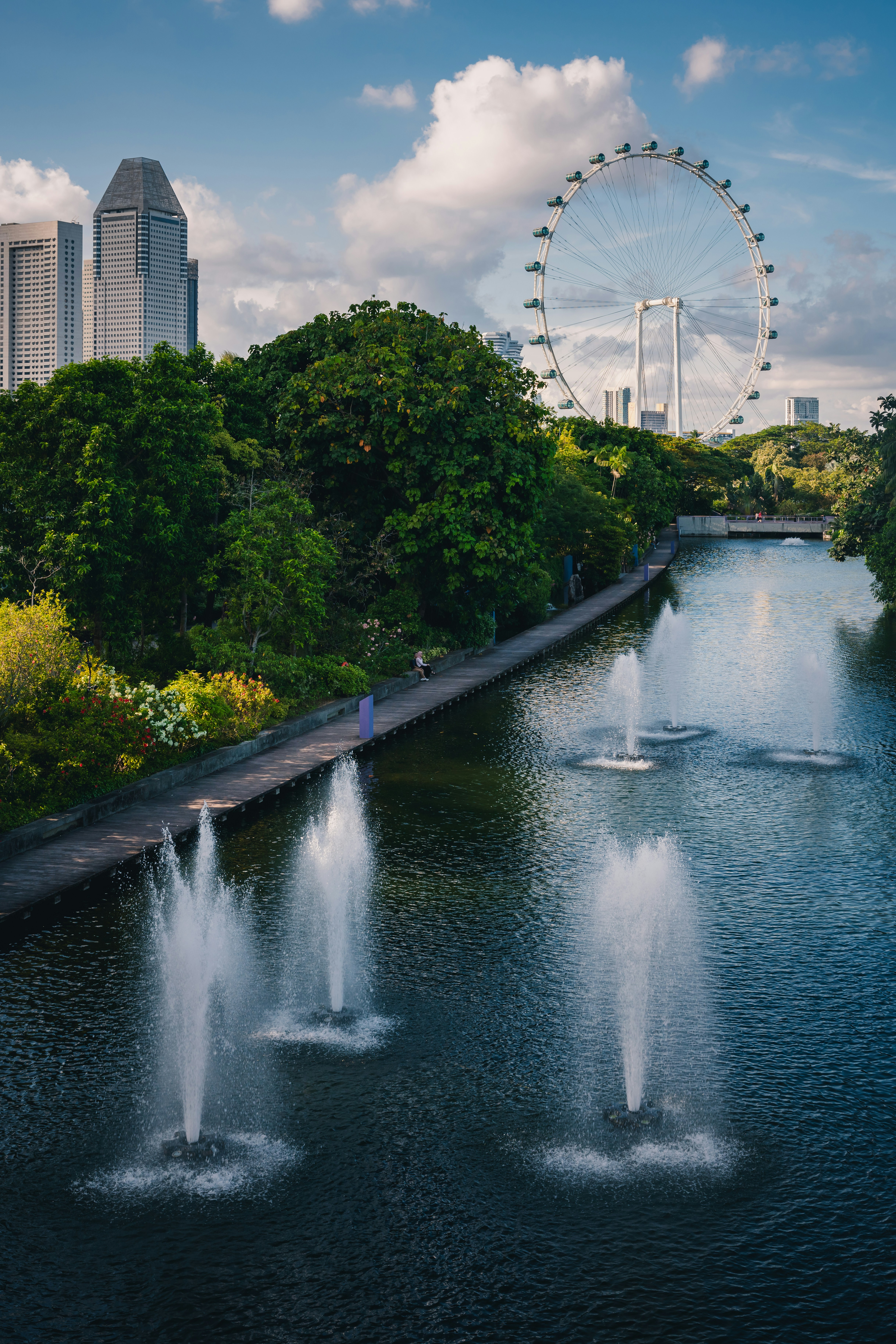 Fountains, ferris wheel, and cityscape in a beautiful park.