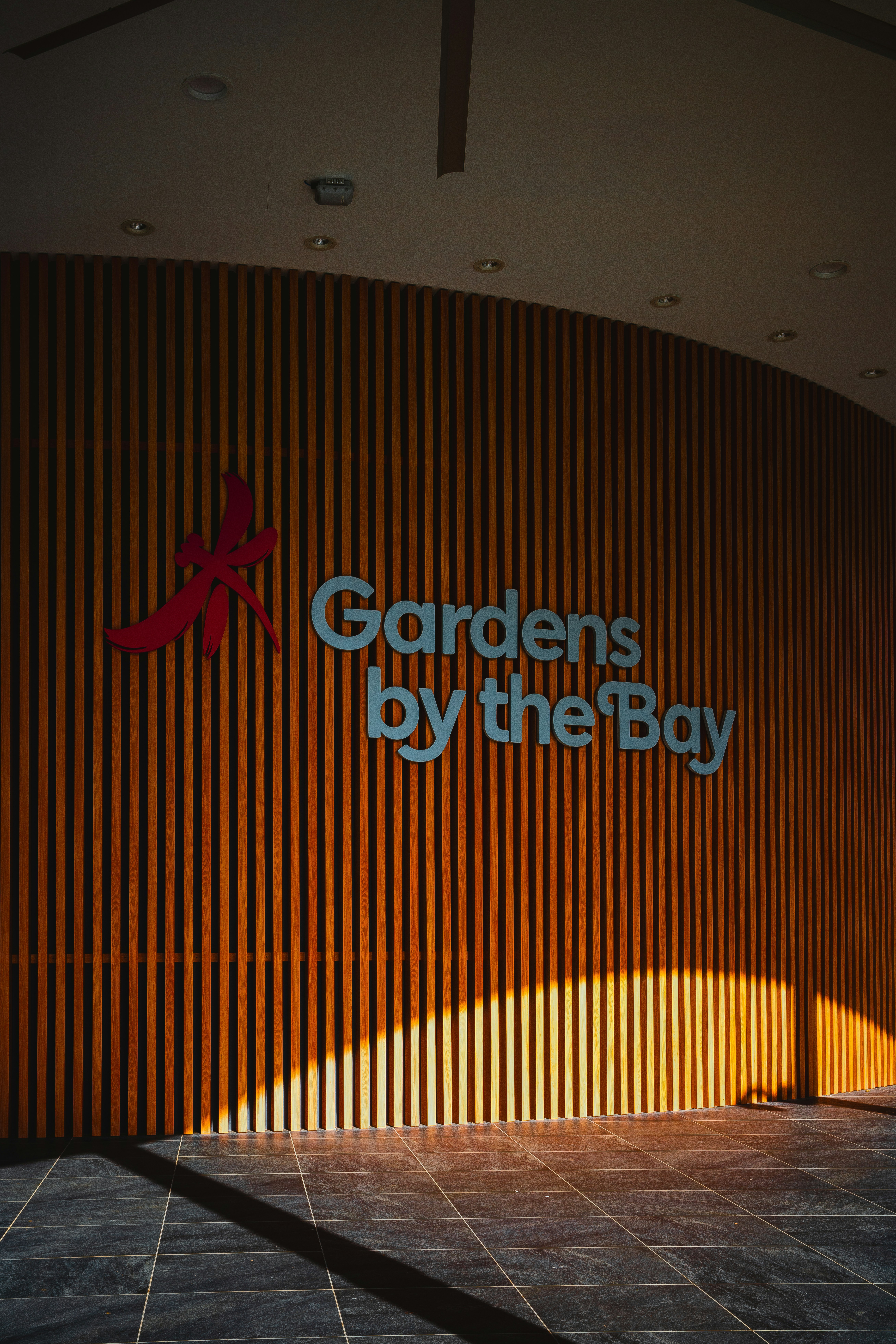 The gardens by the bay sign on a wooden wall.