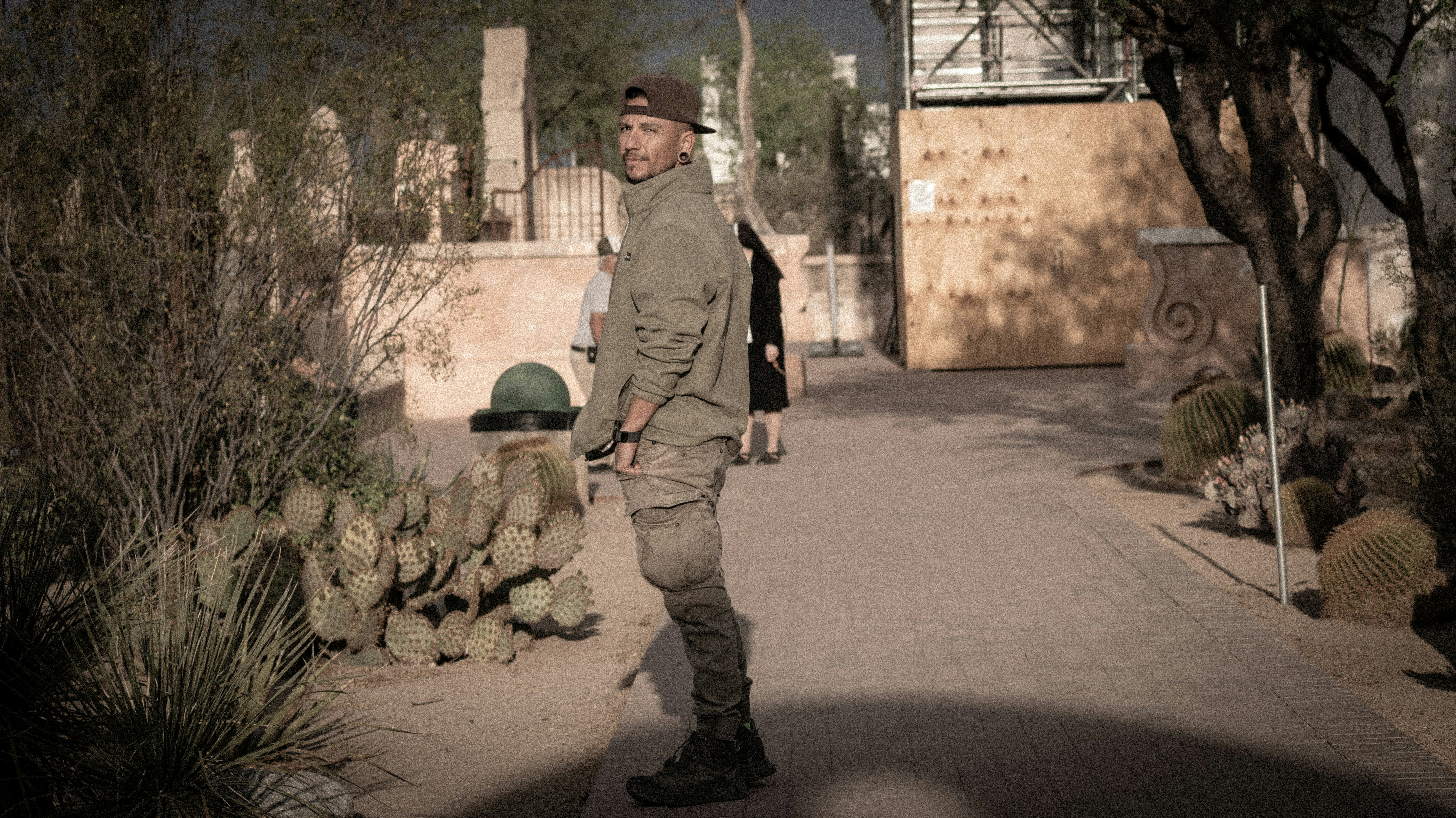 A man stands and looks back on a pathway.