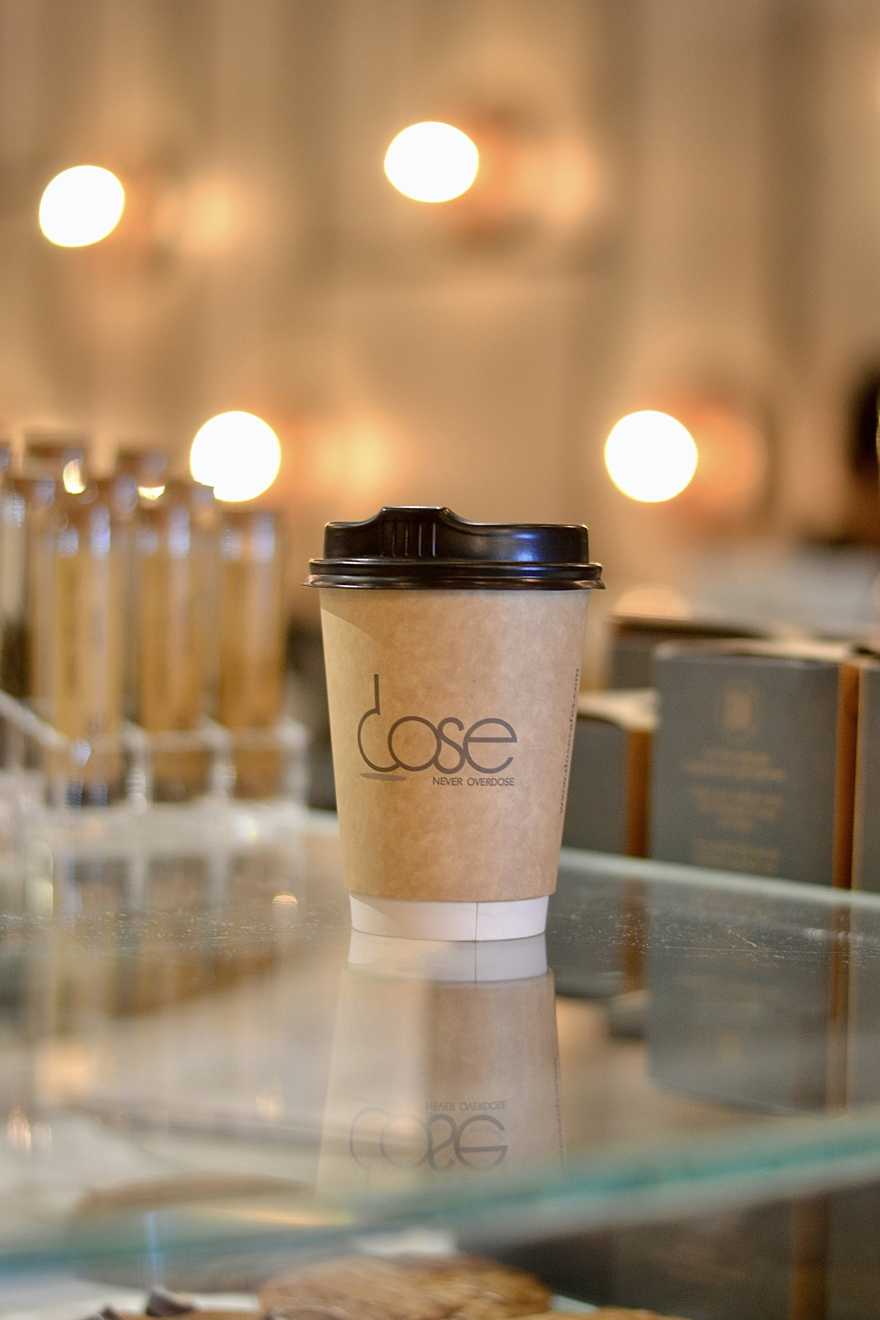 A coffee cup sits on a reflective glass surface.