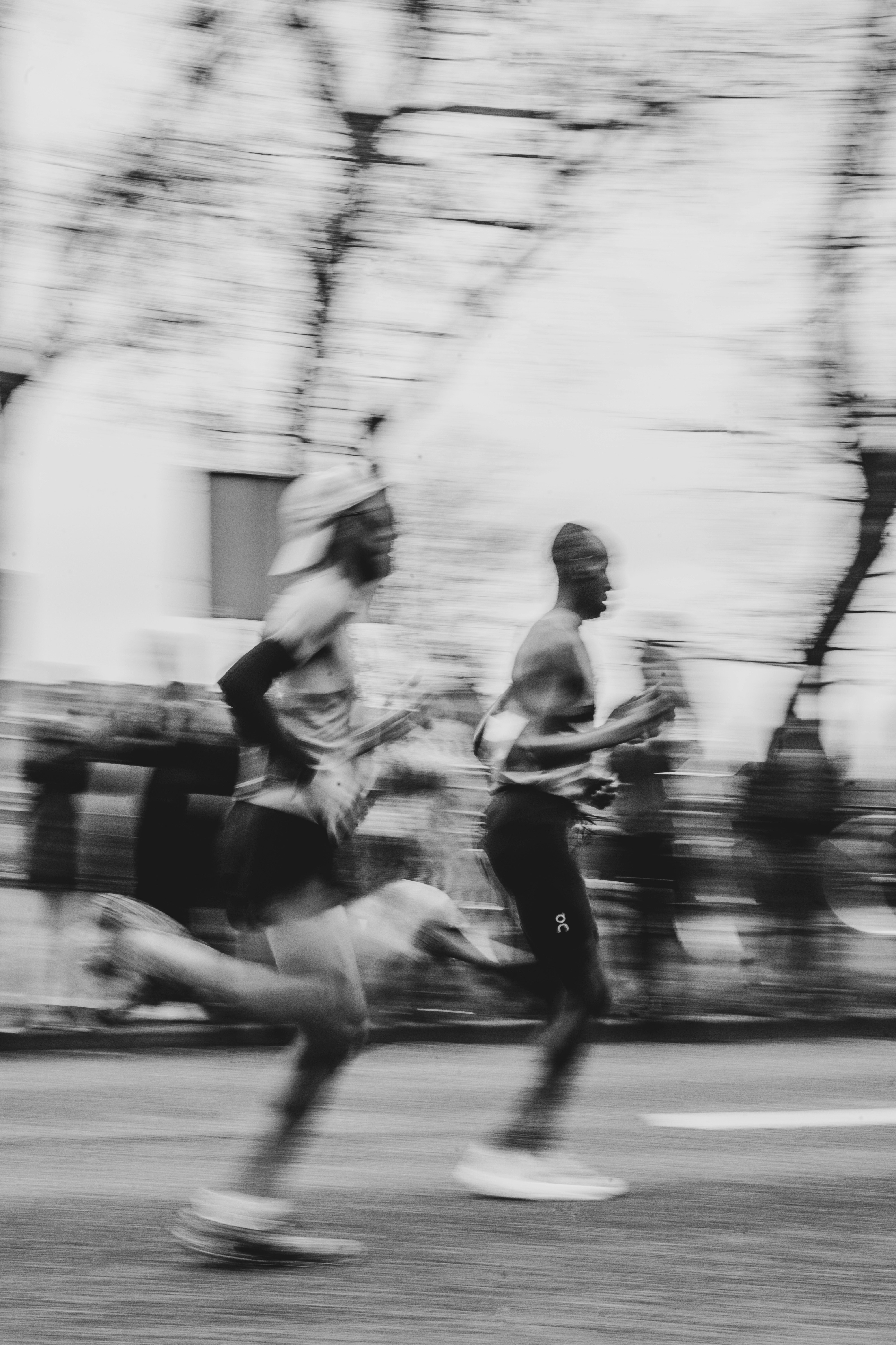 Runners sprint down a street in motion.