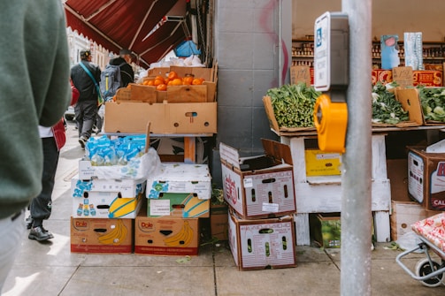 Fresh produce stands on a sidewalk.
