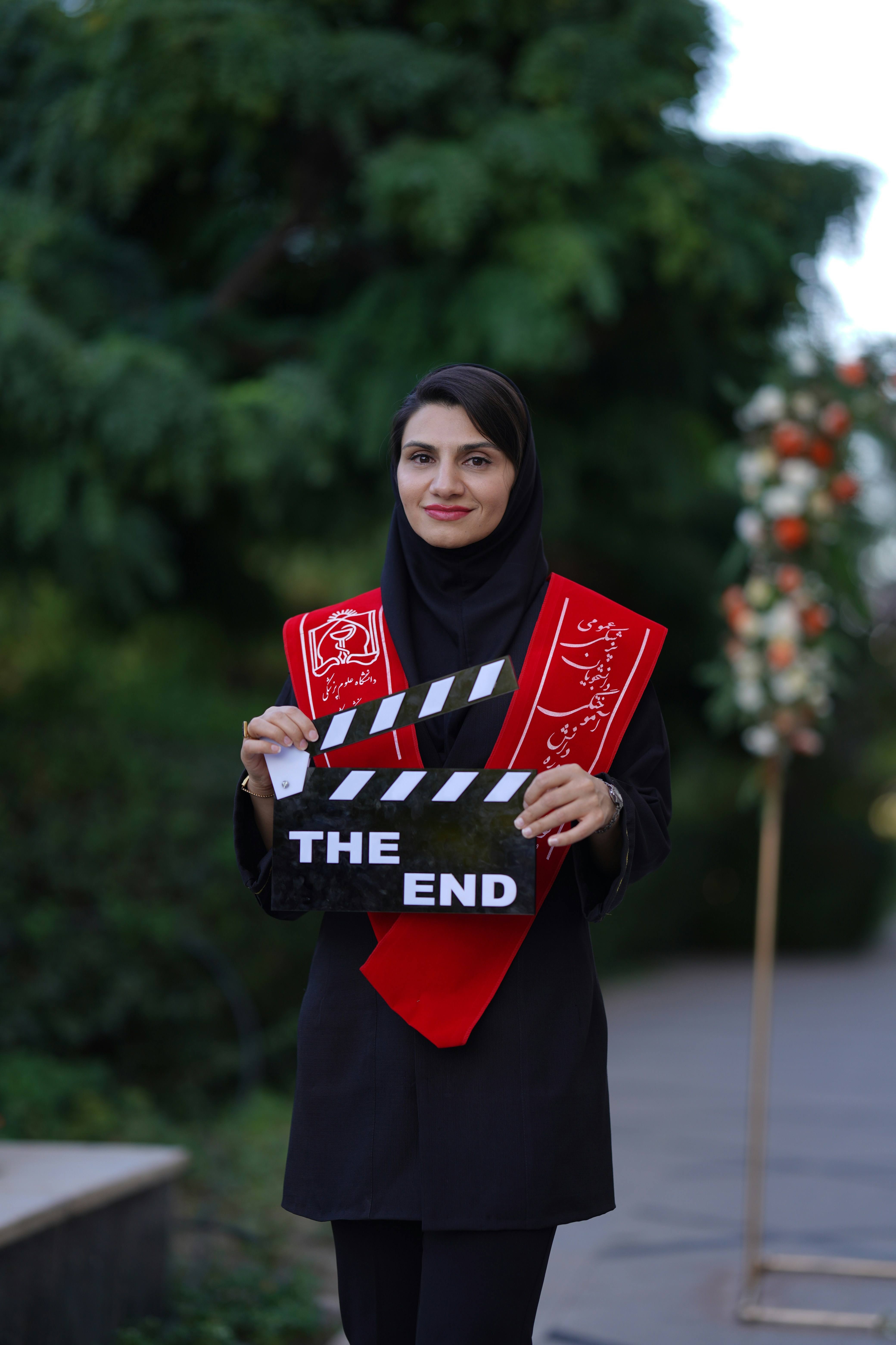 Woman celebrates graduation with a movie clapboard