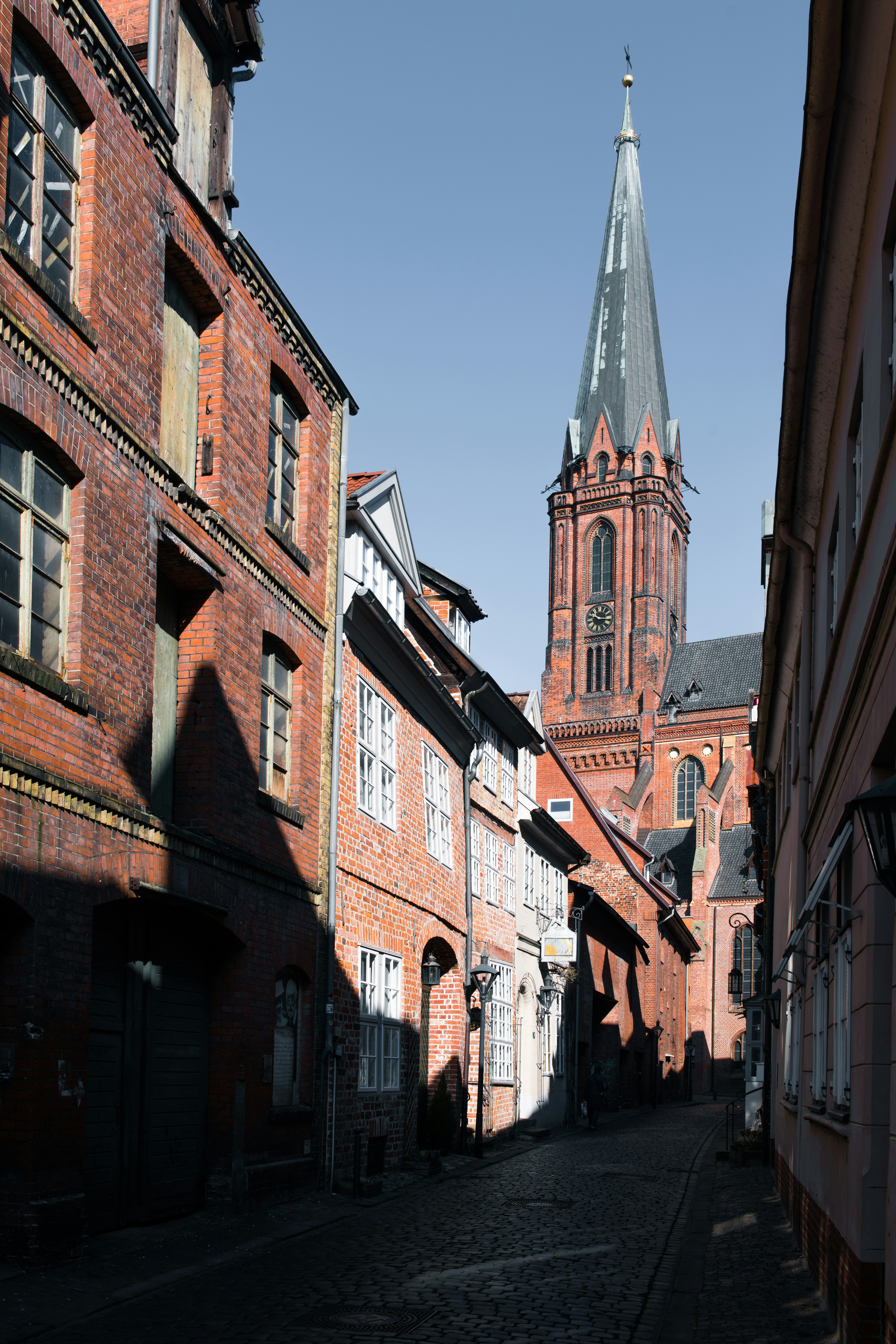 A narrow brick street leads to a church.