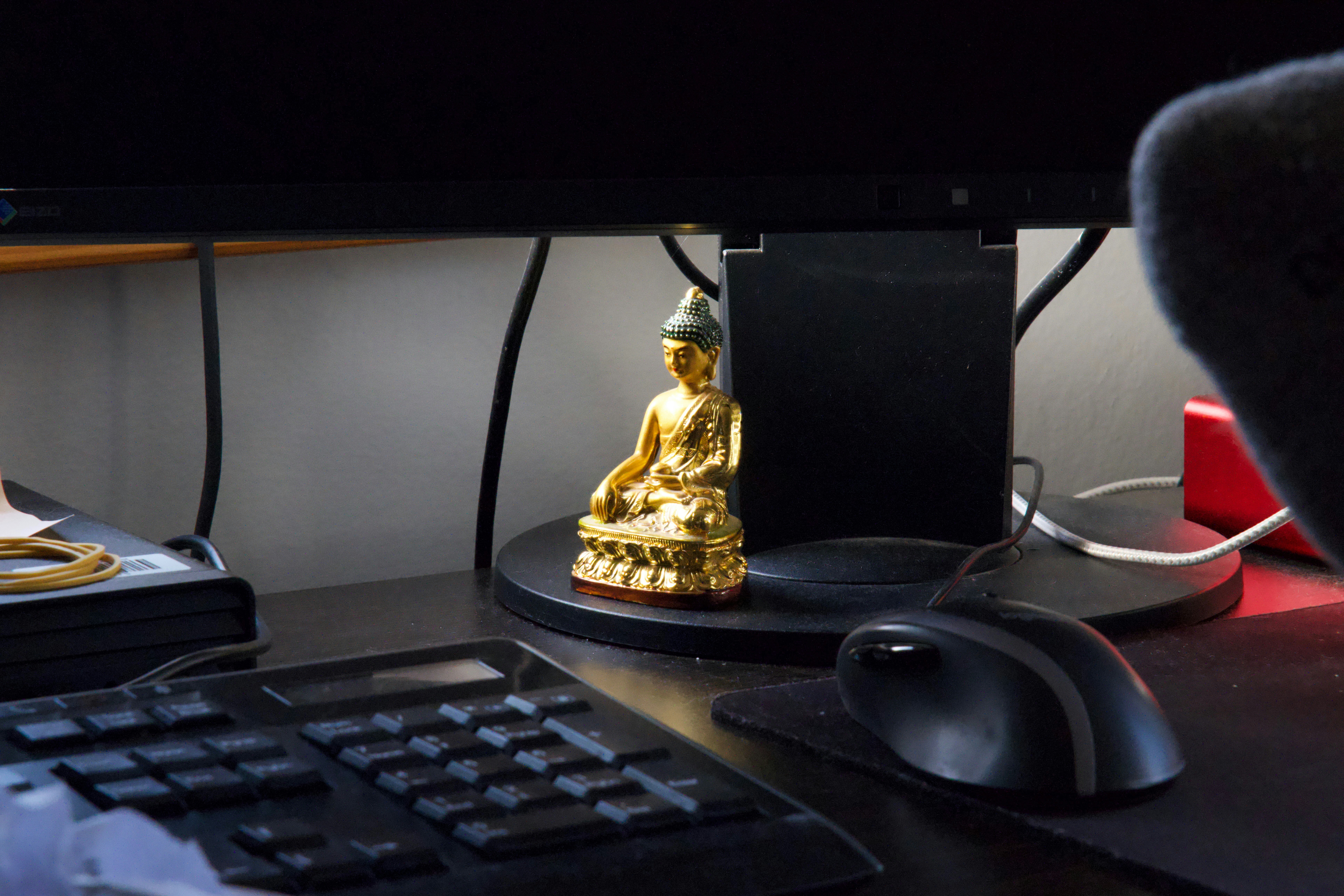 Golden Buddha beneath a computer monitor
