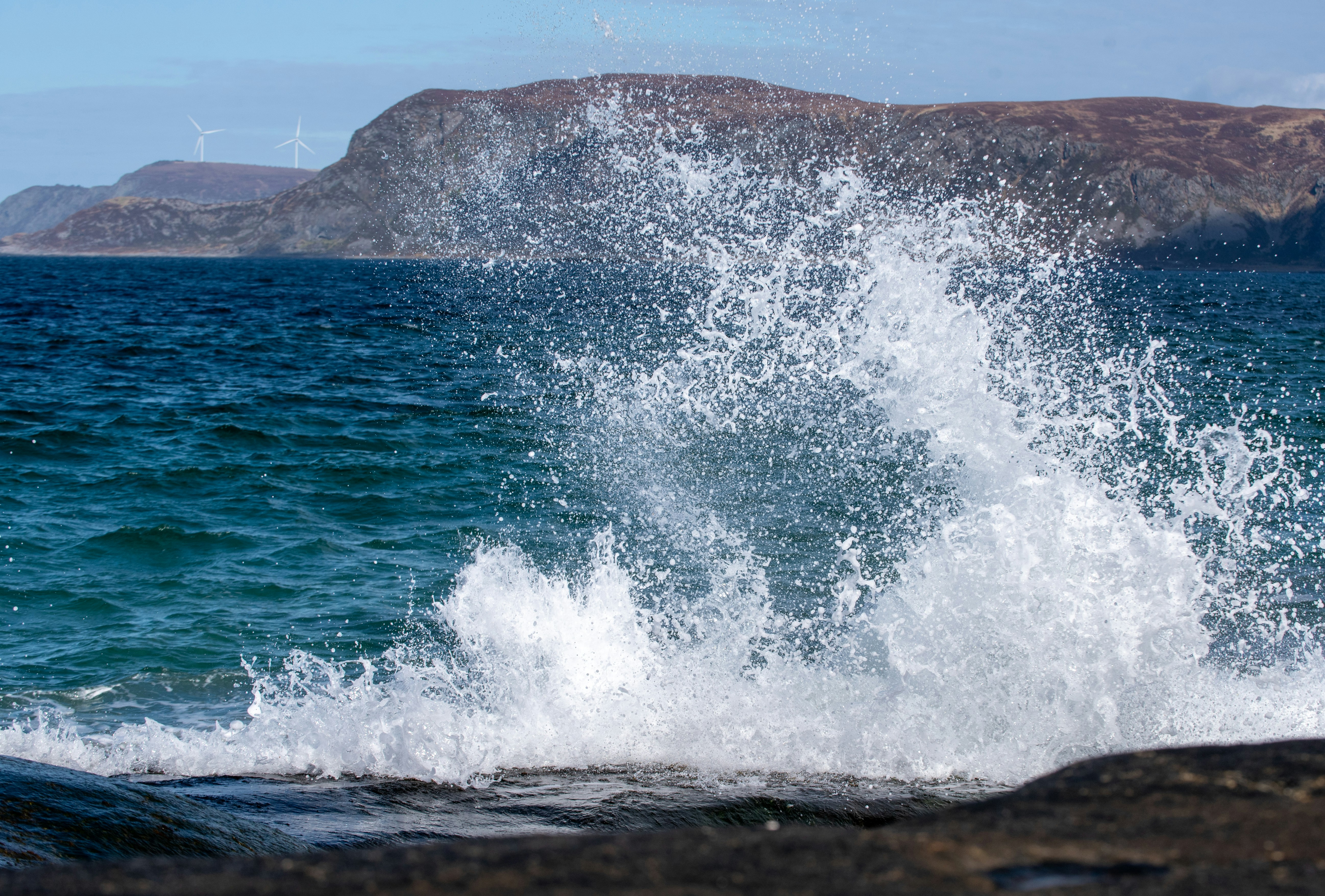 A wave crashes against the shore.
