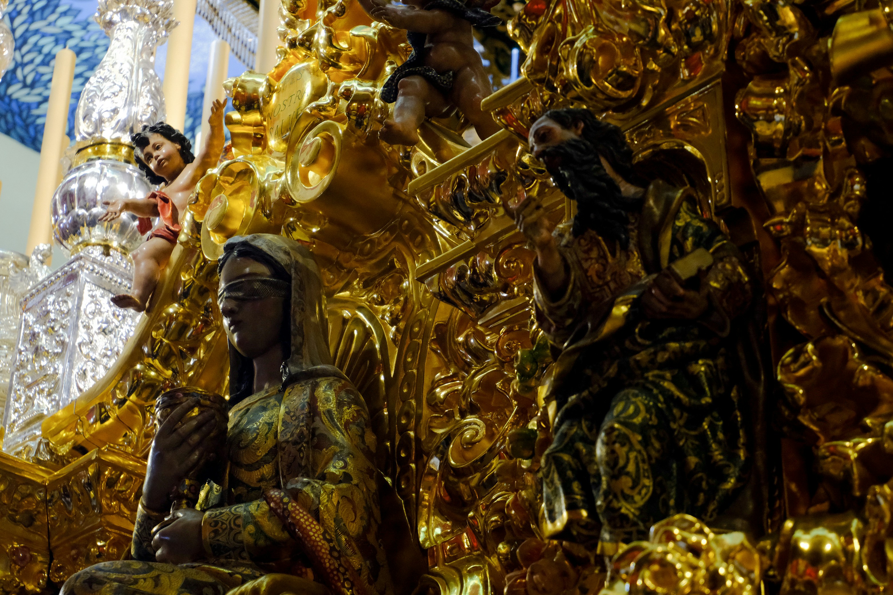Esculturas de ouro ornamentadas adornam um interior.