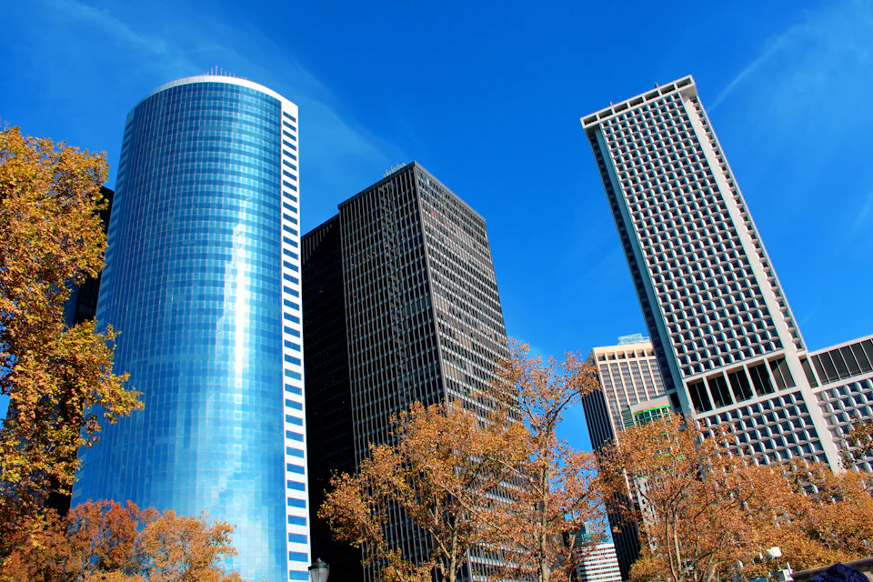 Three distinct buildings in a cityscape featuring unique architectural styles and colors