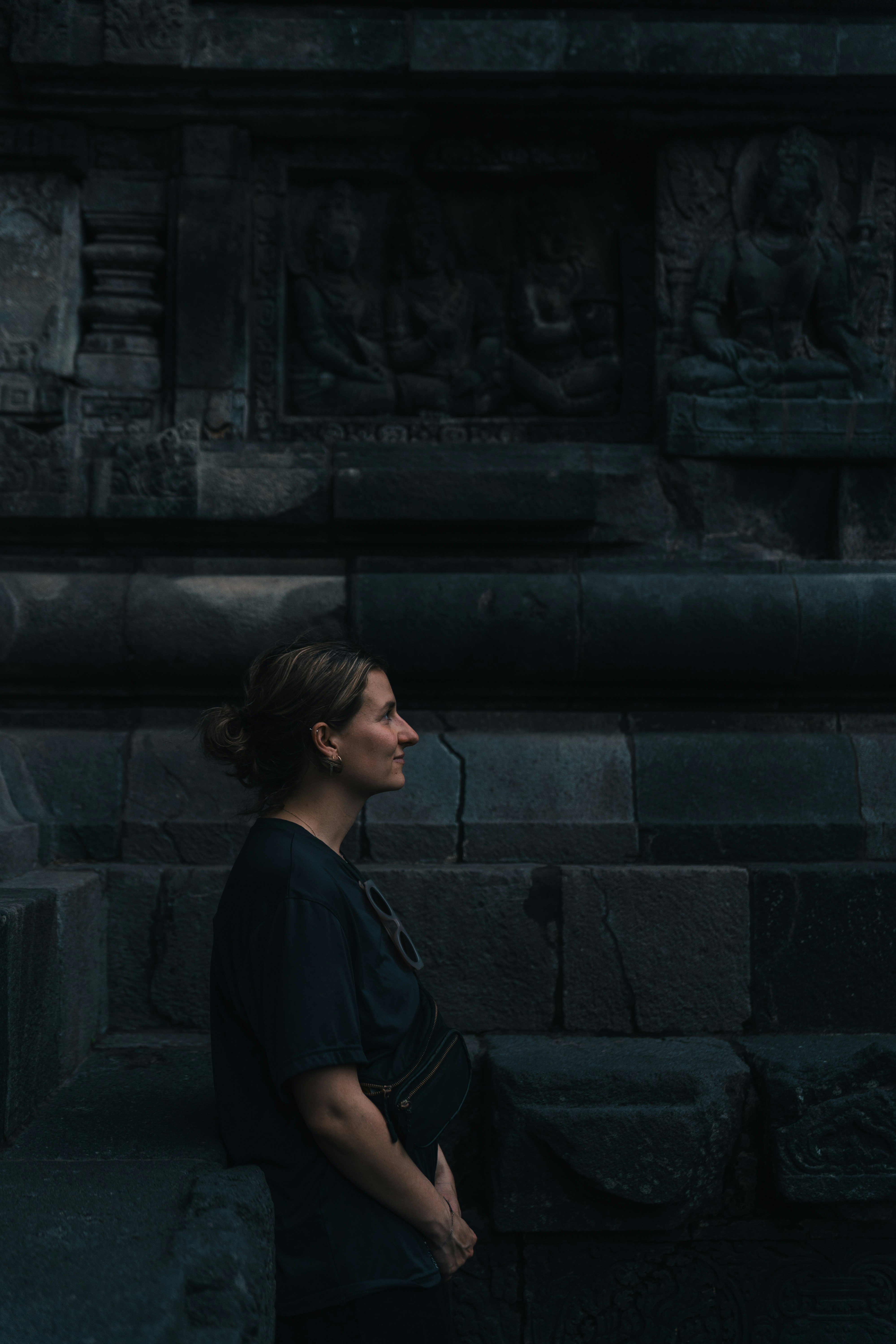 A woman looks at ancient temple carvings.