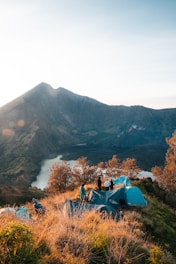 Camping on a mountain overlooking a serene lake.