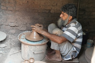 A potter is shaping clay on a spinning wheel.