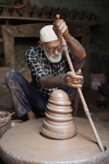 A potter shapes clay on his wheel.