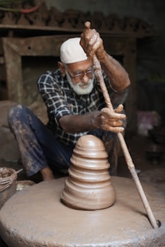 A potter shapes clay on his wheel.