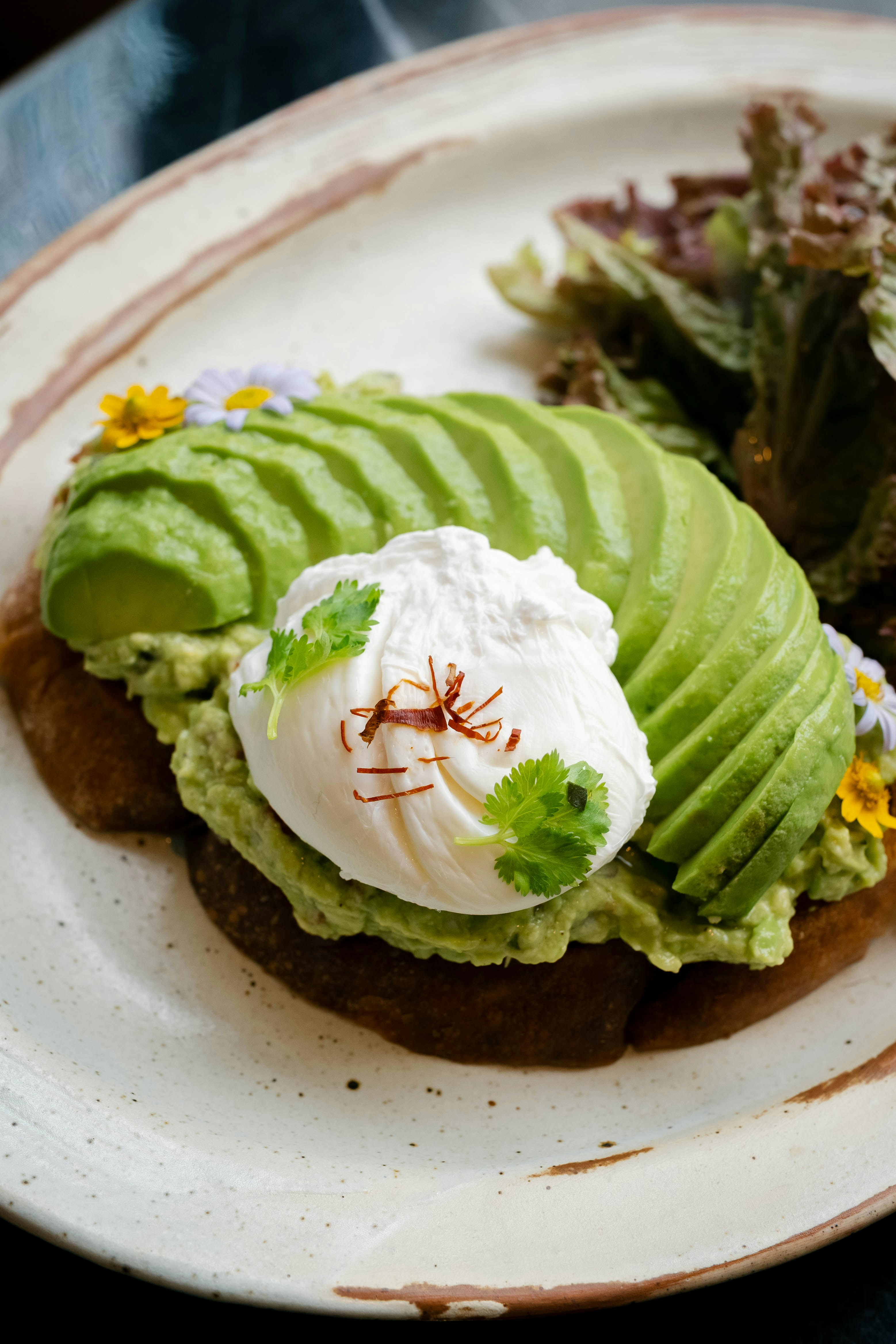 Avocado toast with poached egg and greens.