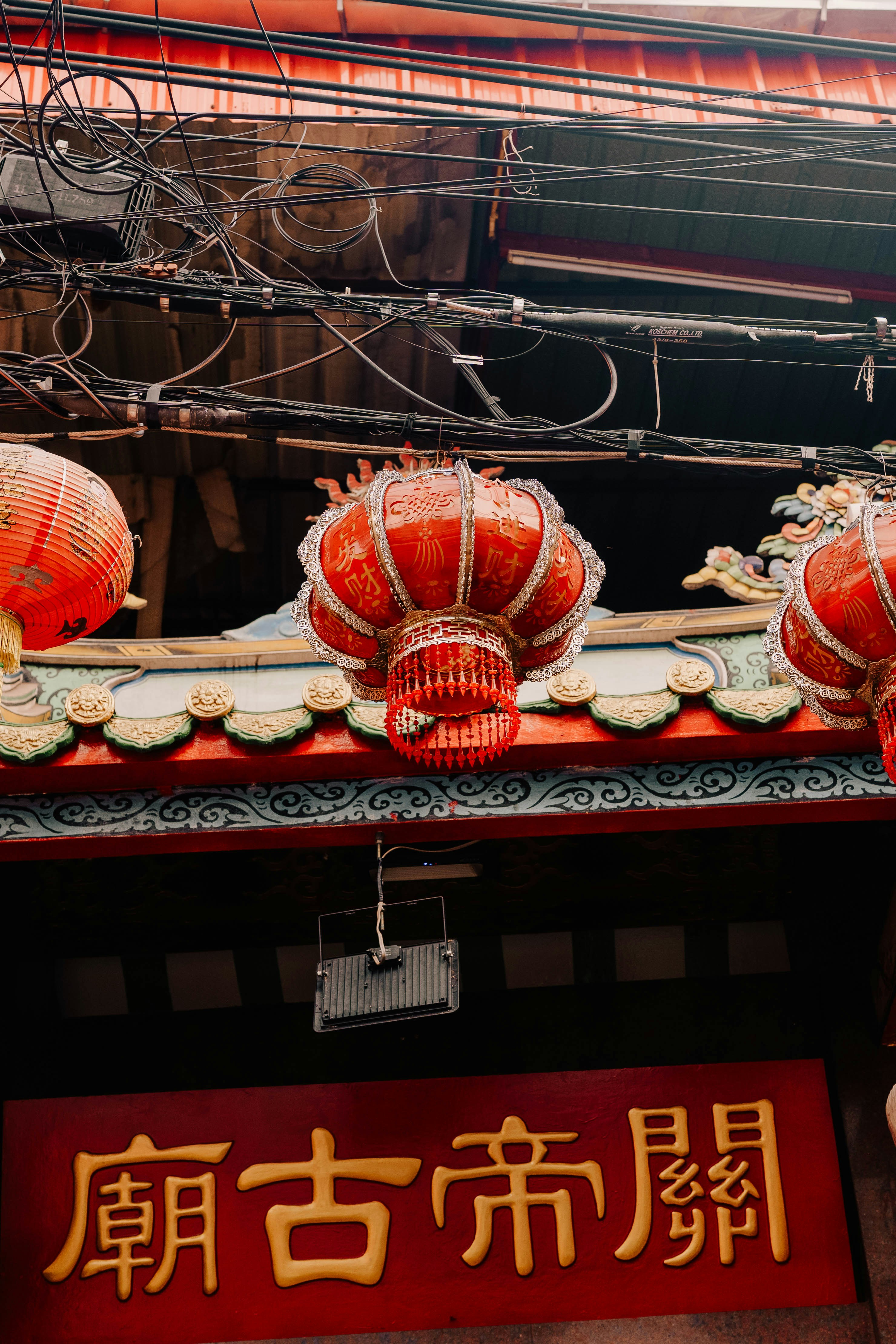 Red lanterns hang from a building's ornate roof.