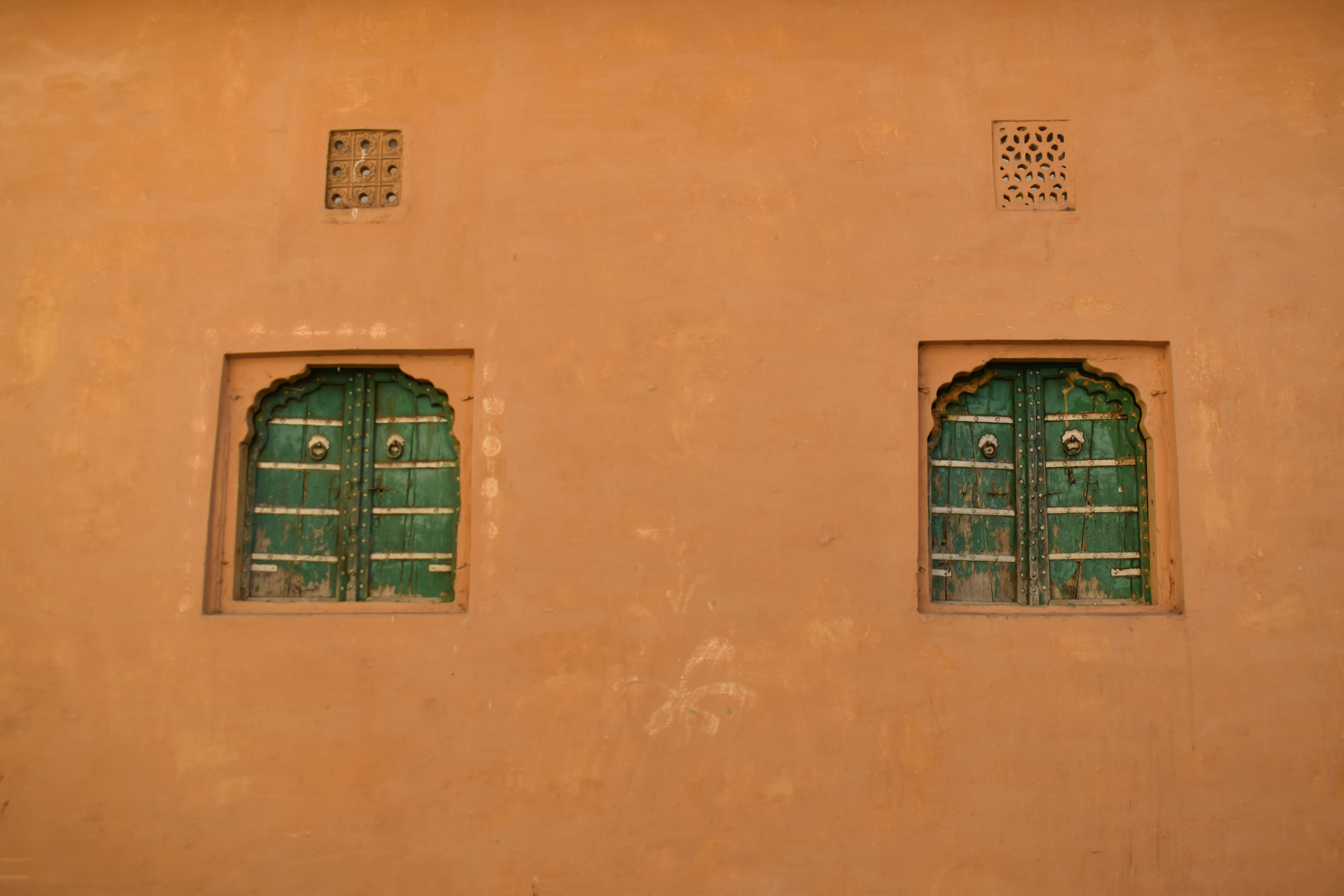 Green windows are set in an orange wall.